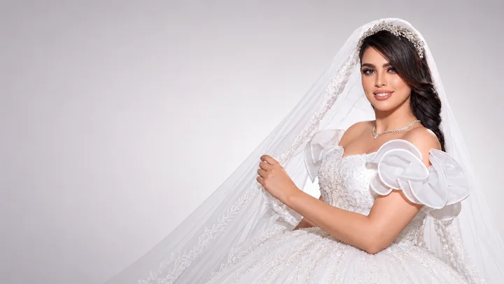 Bridal makeup with softly defined eyes, a nude lip and a sculptural white wedding dress