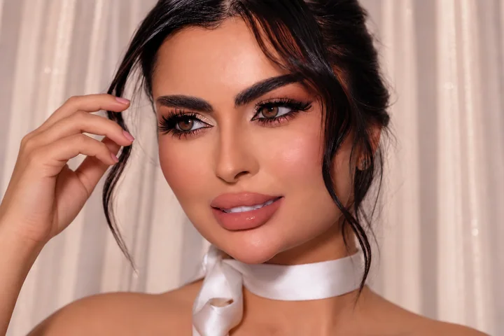 Defined eyes and glossy peach lips with a satin neck ribbon